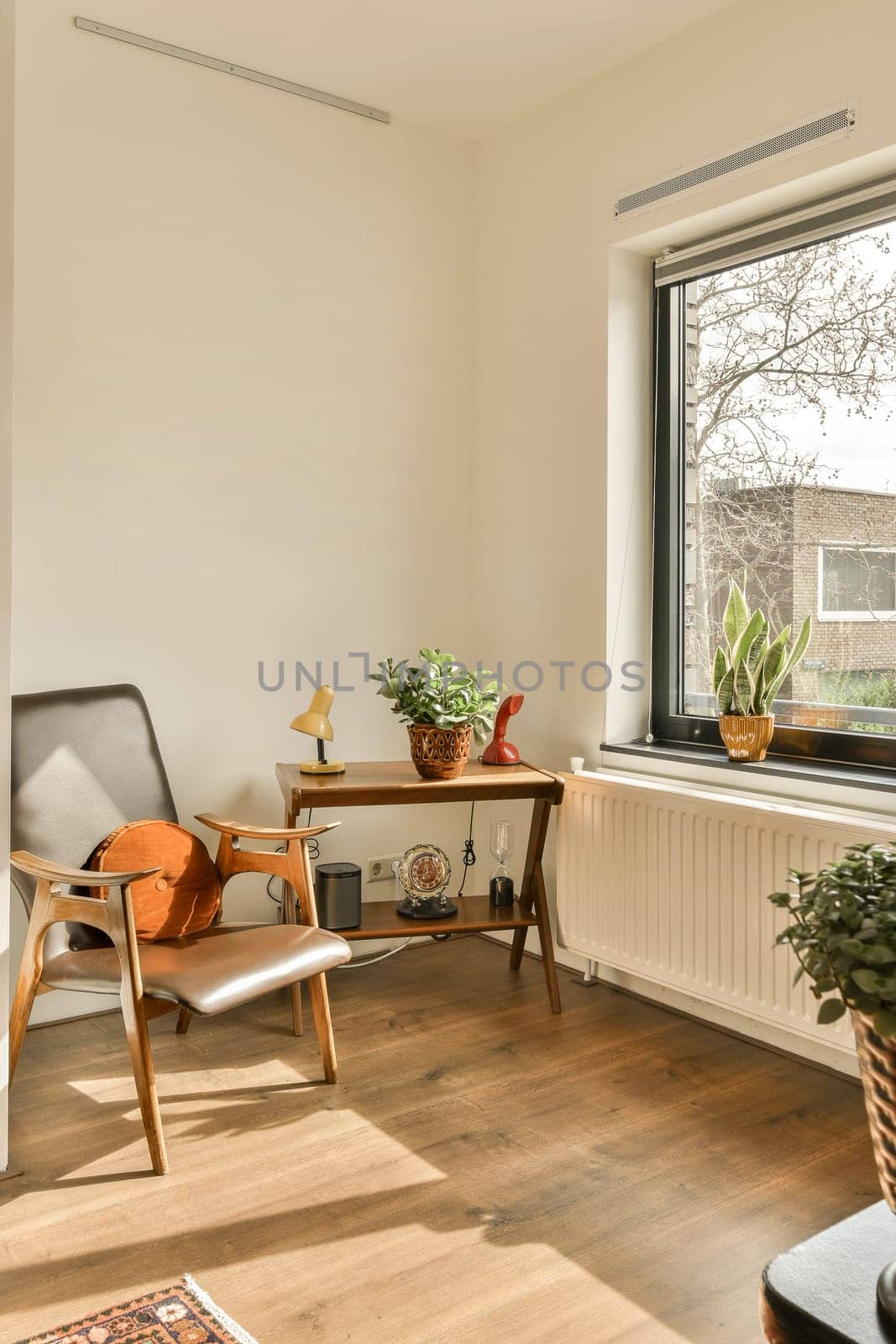 a living room with some plants in the window sies and an old chair on the floor next to it