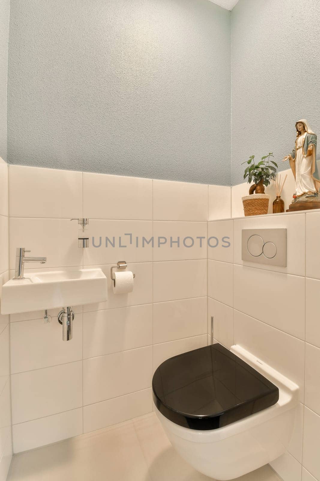 a bathroom with a toilet, sink and plant on the shelf over the toilet bowl in the wall is white