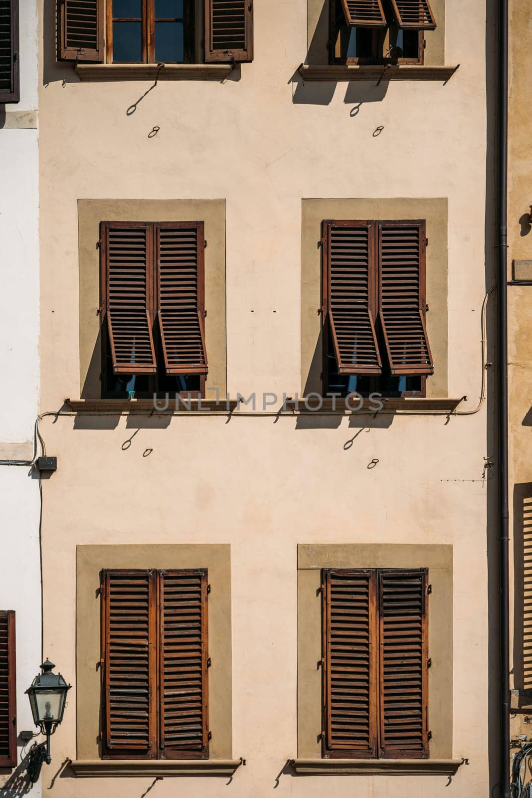 Close-up of an amazing old traditional Italian stone house with lattice shutters in Florence on a sunny warm summer day. The concept of traditional Italian houses. Copyspace by apavlin