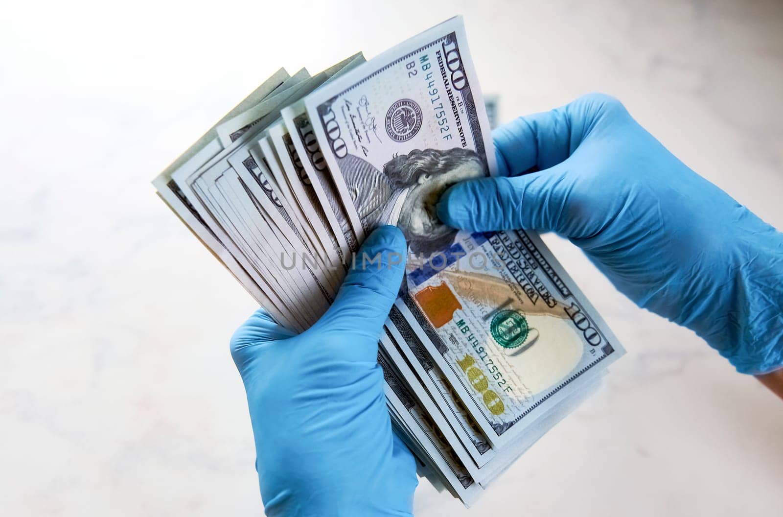 secure money transfer. hand in a rubber glove takes money. hands in sterile medical gloves.