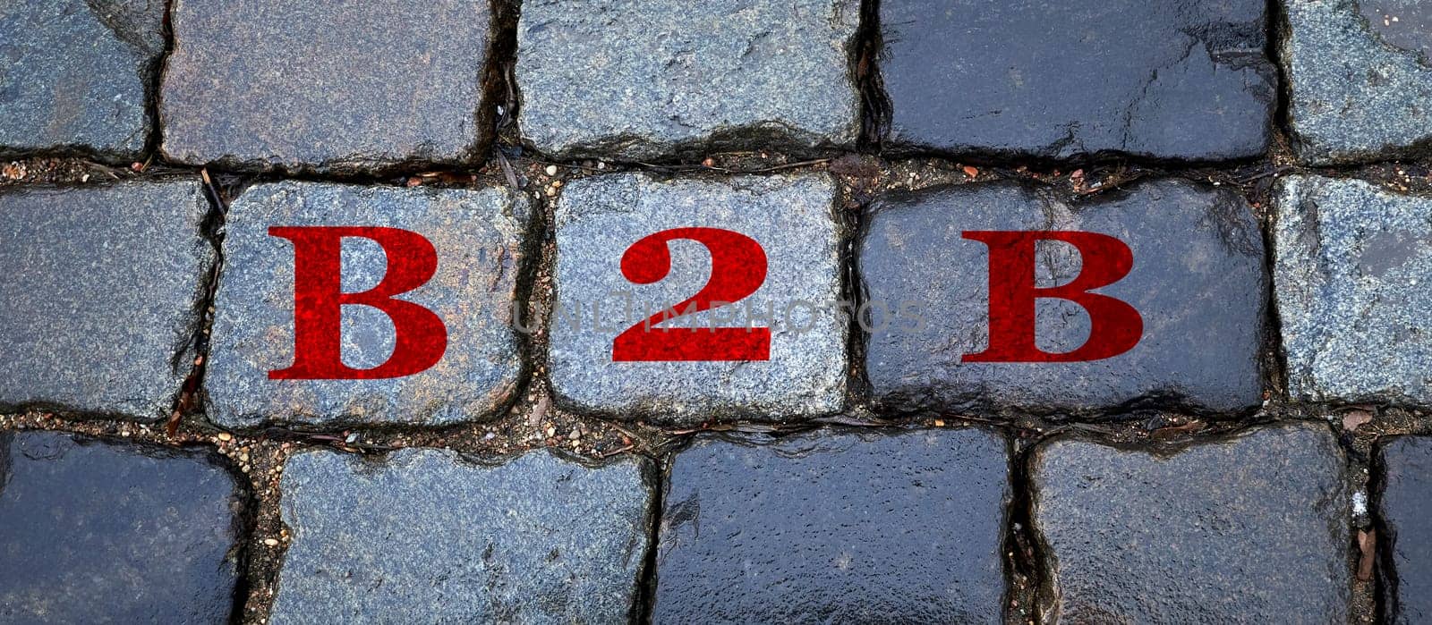 B2B is written on a wet stone gray wall in big letters. by Hil