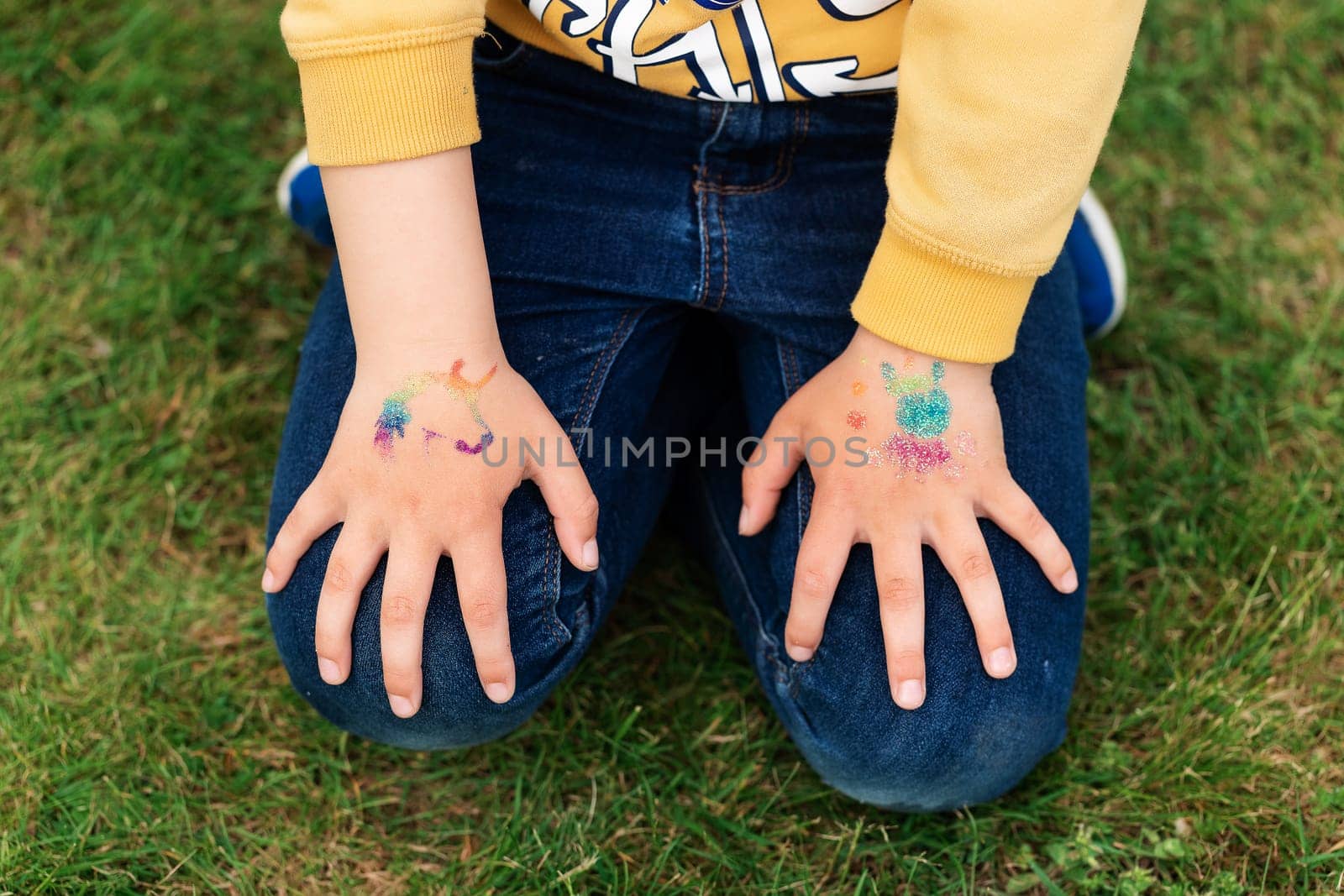 Shimmering sparkling glitter tattoo on a child's hand at a birthday party by Len44ik