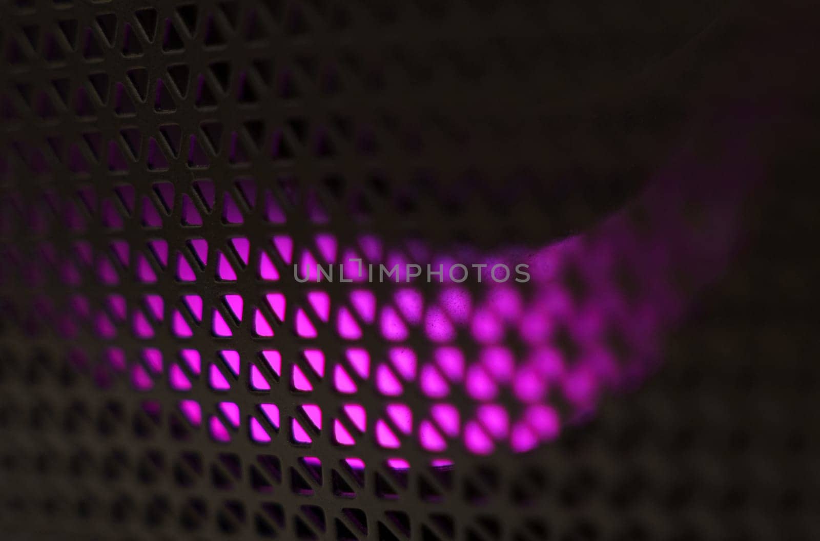 Abstract background of a black patterned lattice behind which purple LEDs glow.