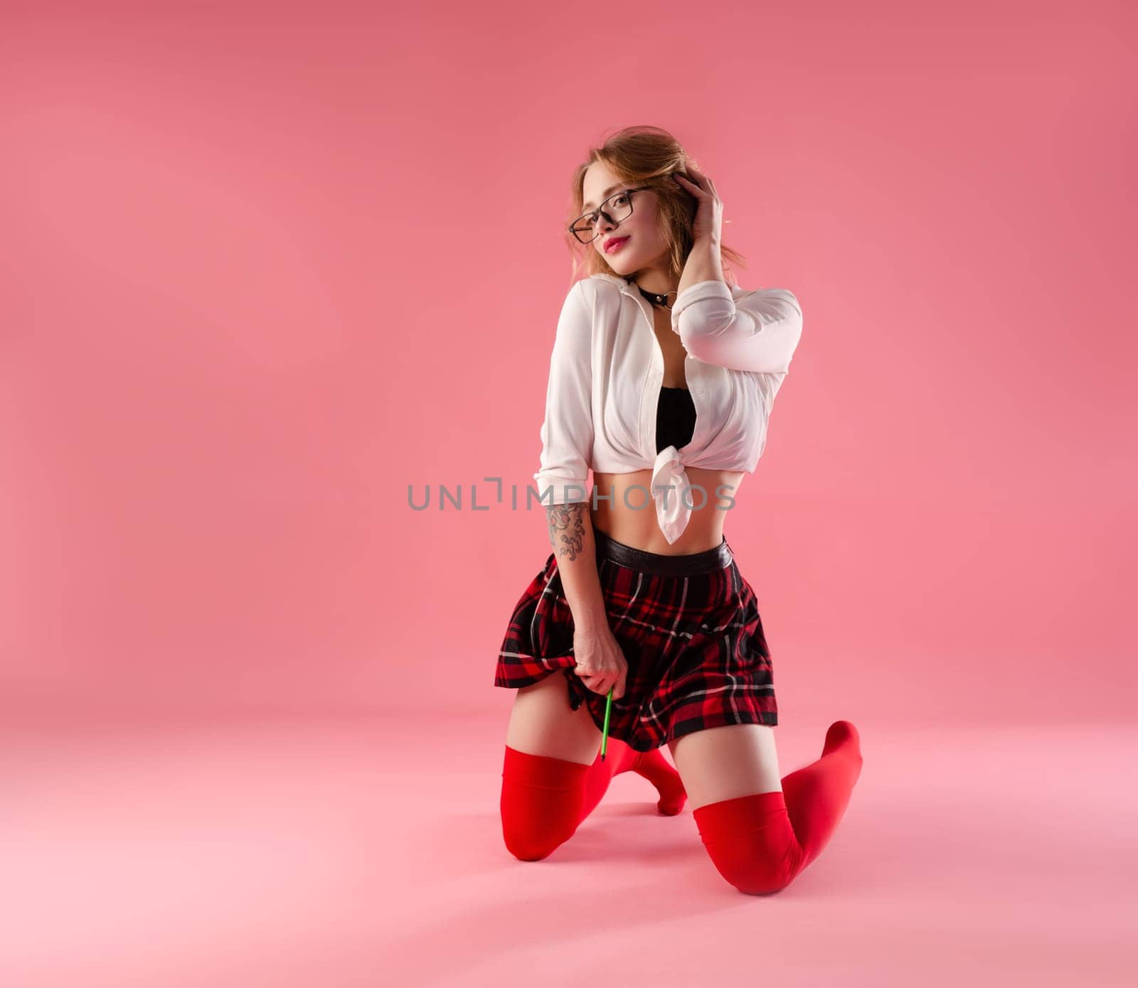sexy girl sexy schoolgirl costume with glasses on pink background copy paste