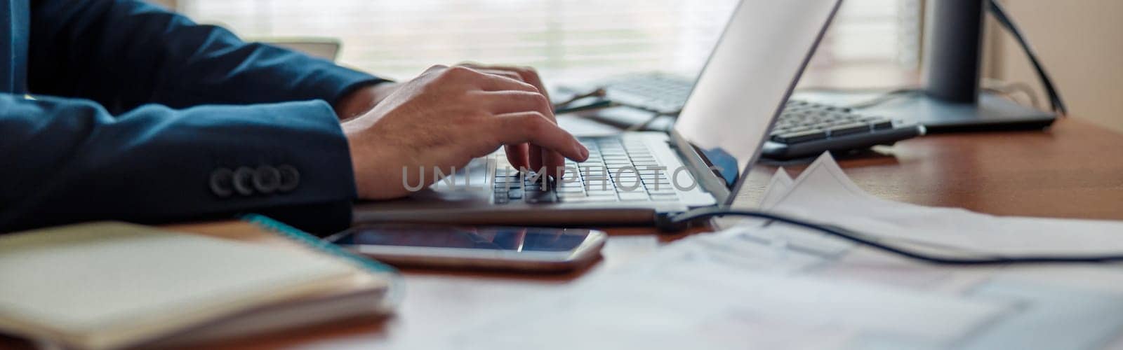 Close up of businessman hands working on laptop in home office. High quality photo