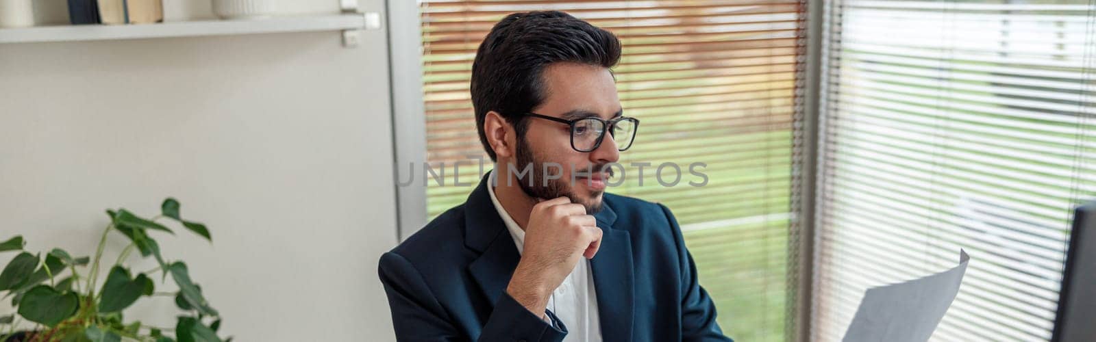 Focused indian businessman in suit working on project from home office . Freelance concept