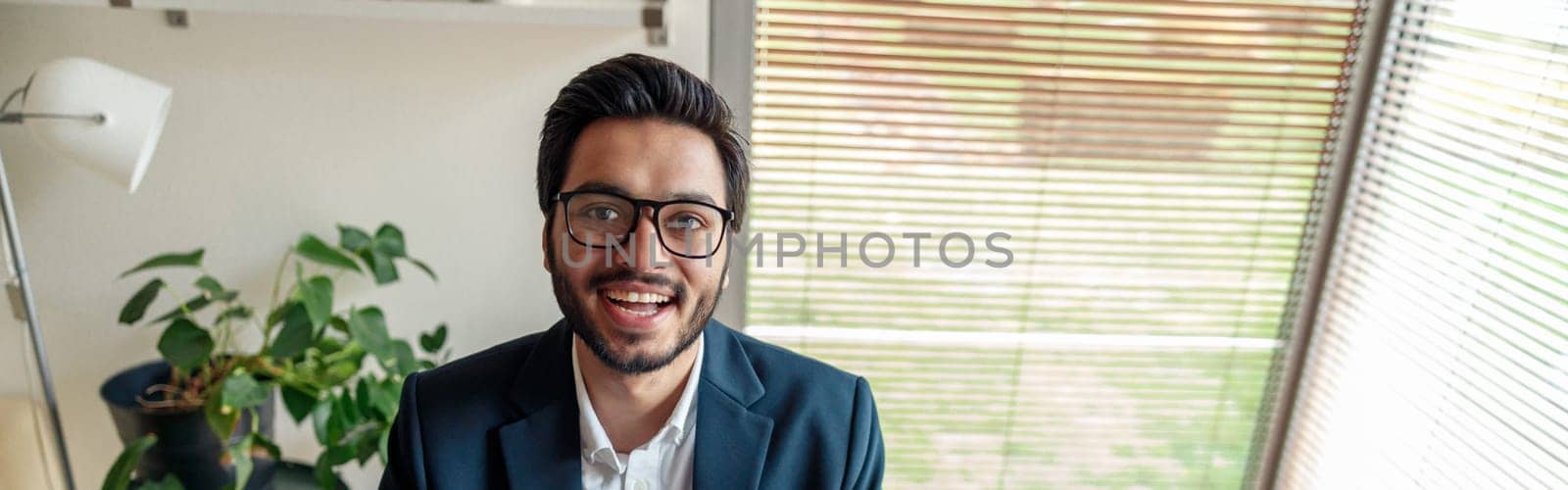 Smiling indian businessman in suit working on project from home office . Freelance concept