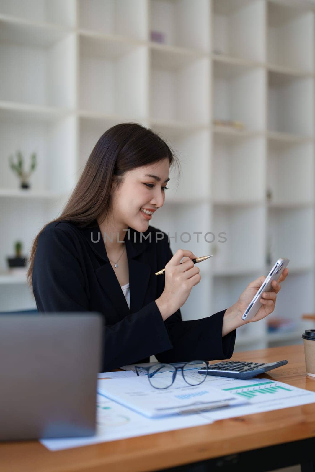 Excited businesswoman using mobile phone while in office , business concepts. by Manastrong