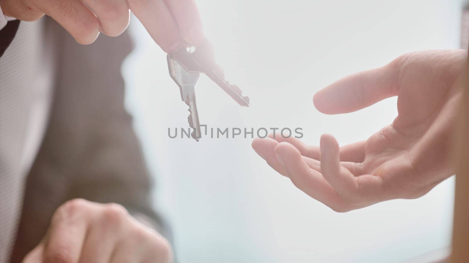 World leasing day concept. Realtor gives the keys to the new owner. Close-up of hands. Rental and purchase of real estate