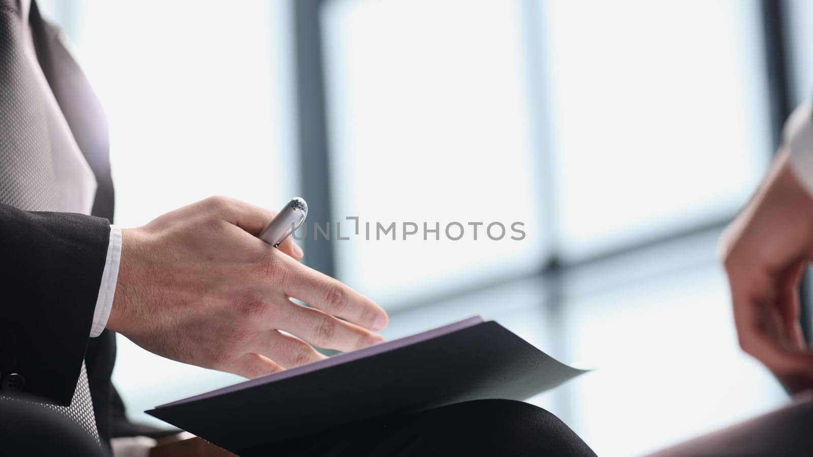 manager holding business documents and a pen while talking