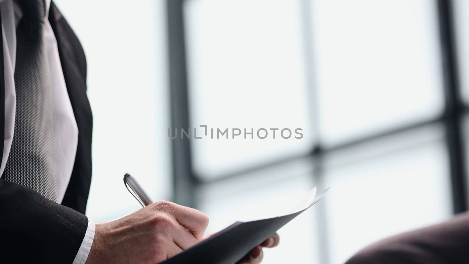 manager holding business documents and a pen while talking