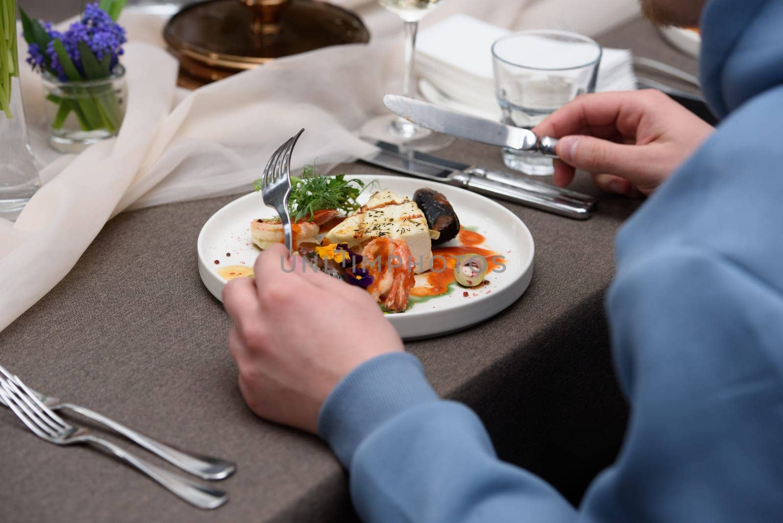 saganaki, traditional Greek cheese snack served on a table in a restaurant. halloumi cheese with shrimp and mussels. micro green topping