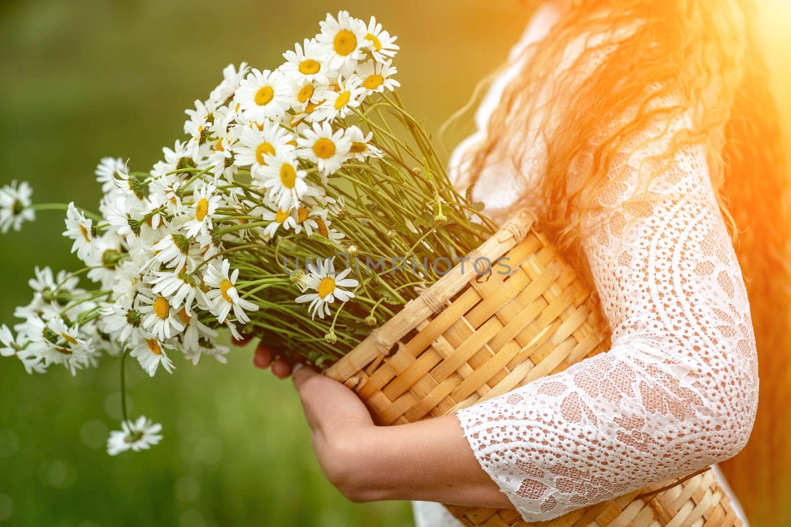 A middle-aged woman holds a large bouquet of daisies in her hands. Wildflowers for congratulations.