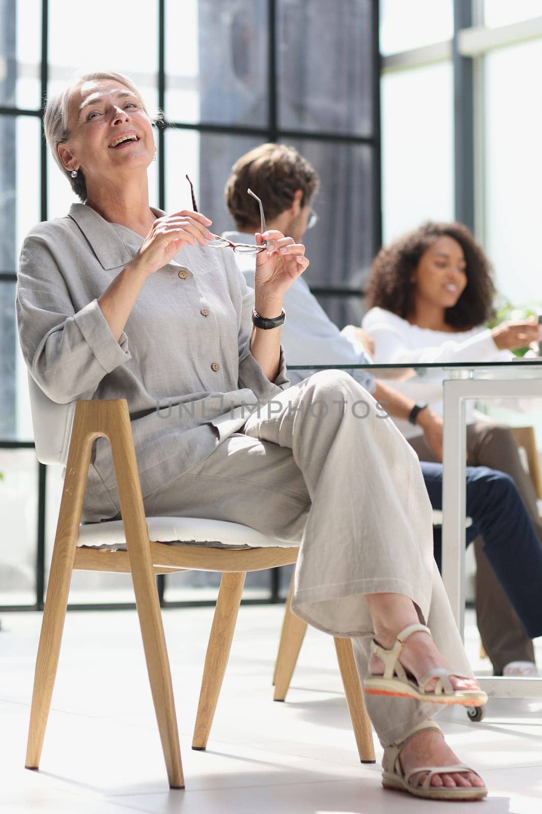 mature woman sitting with laptop looking at camera.