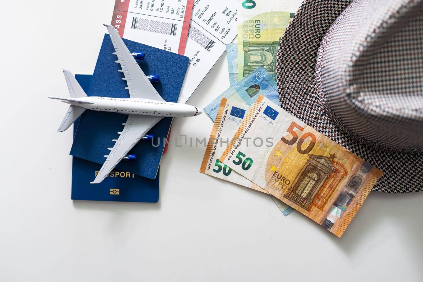 Travel accessories on the light boards. Hat, camera, document holder with passport, glasses.