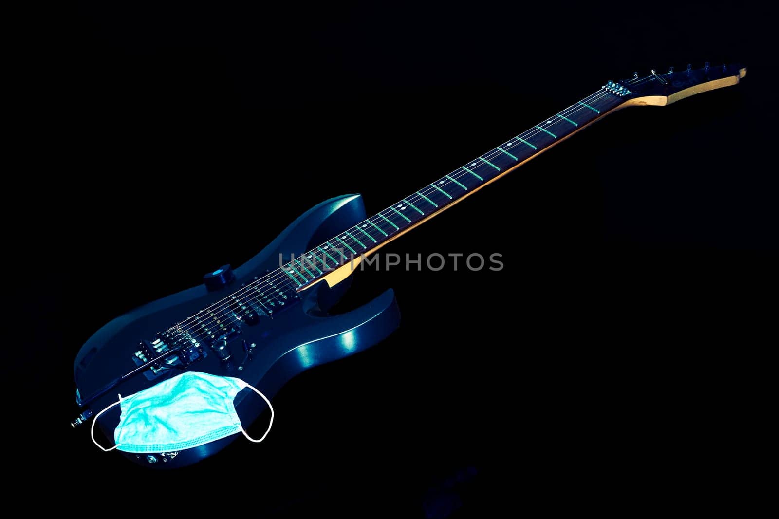 Kyiv, Ukraine, April 30,2020. Electric guitar Cort on black, protective mask by jovani68