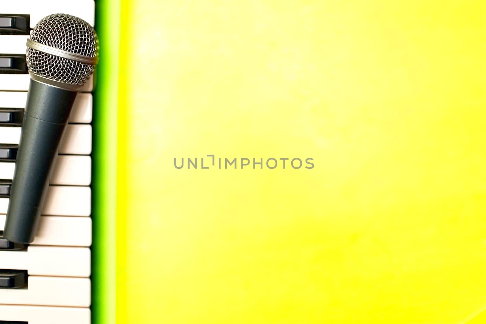 Piano synthesizer keys and microphone on yellow background.Place for text by jovani68