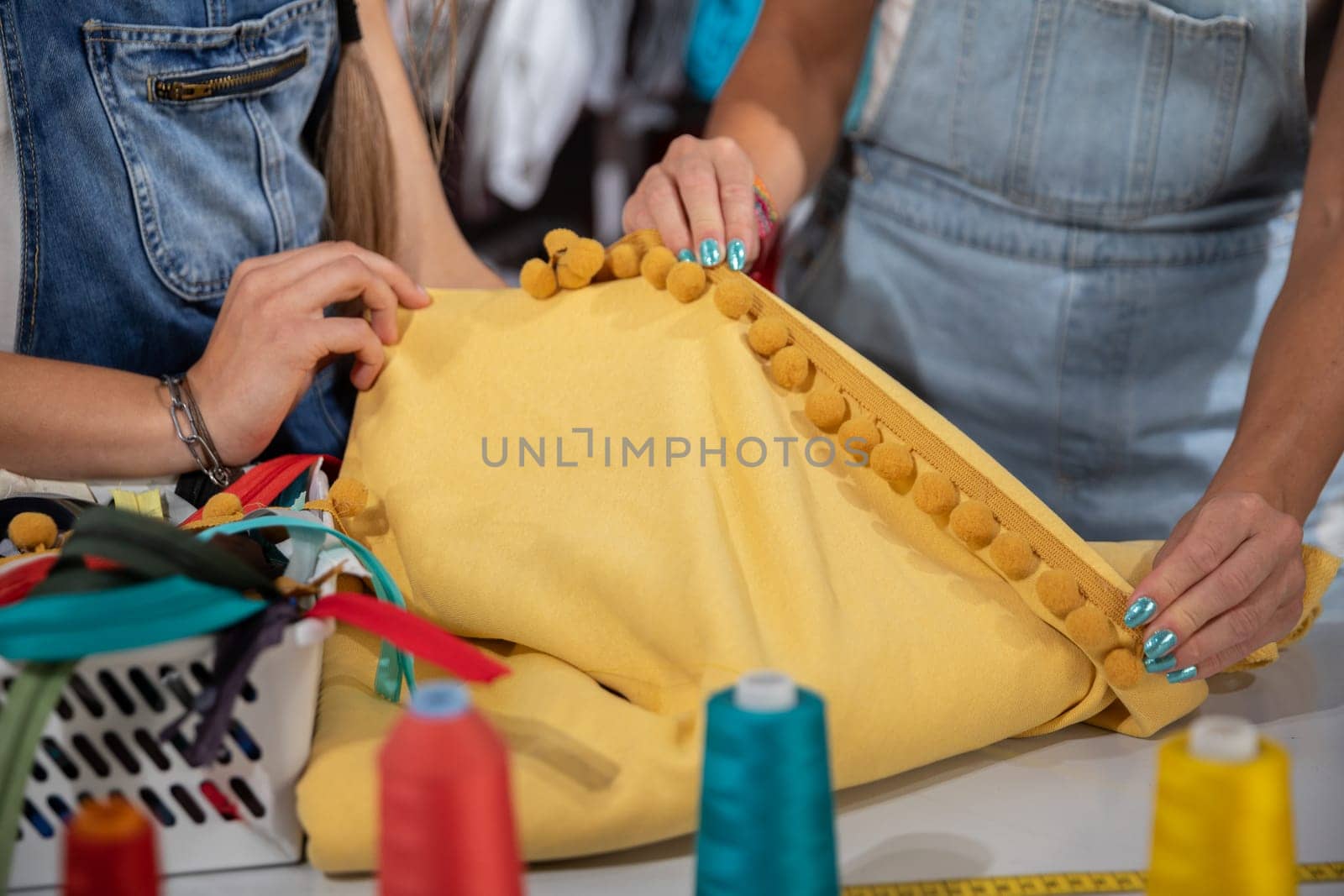 Two clothing designers while working together on one clothing project. Creative work in the back of the tailor's studio.