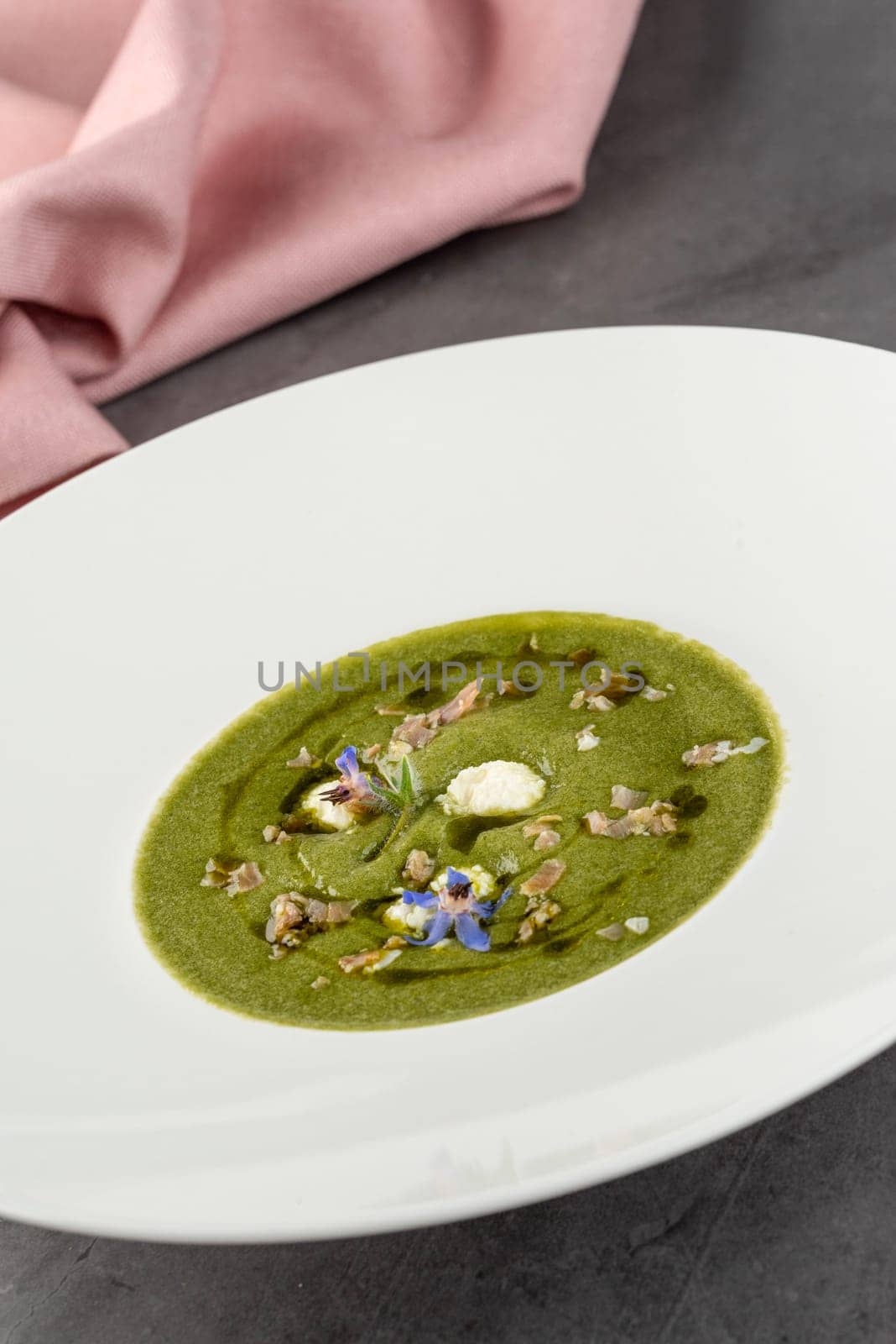 Healthy broccoli soup with meat and cream on a white porcelain plate by Sonat