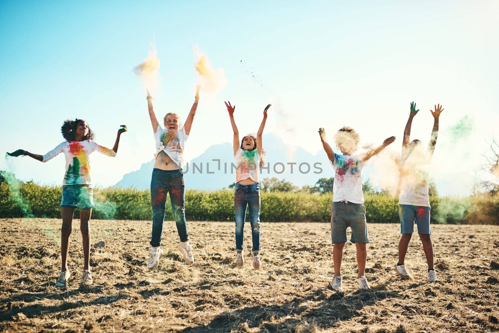 Summer camp makes everything better and brighter. a group of teenagers having fun with colourful powder at summer camp. by YuriArcurs