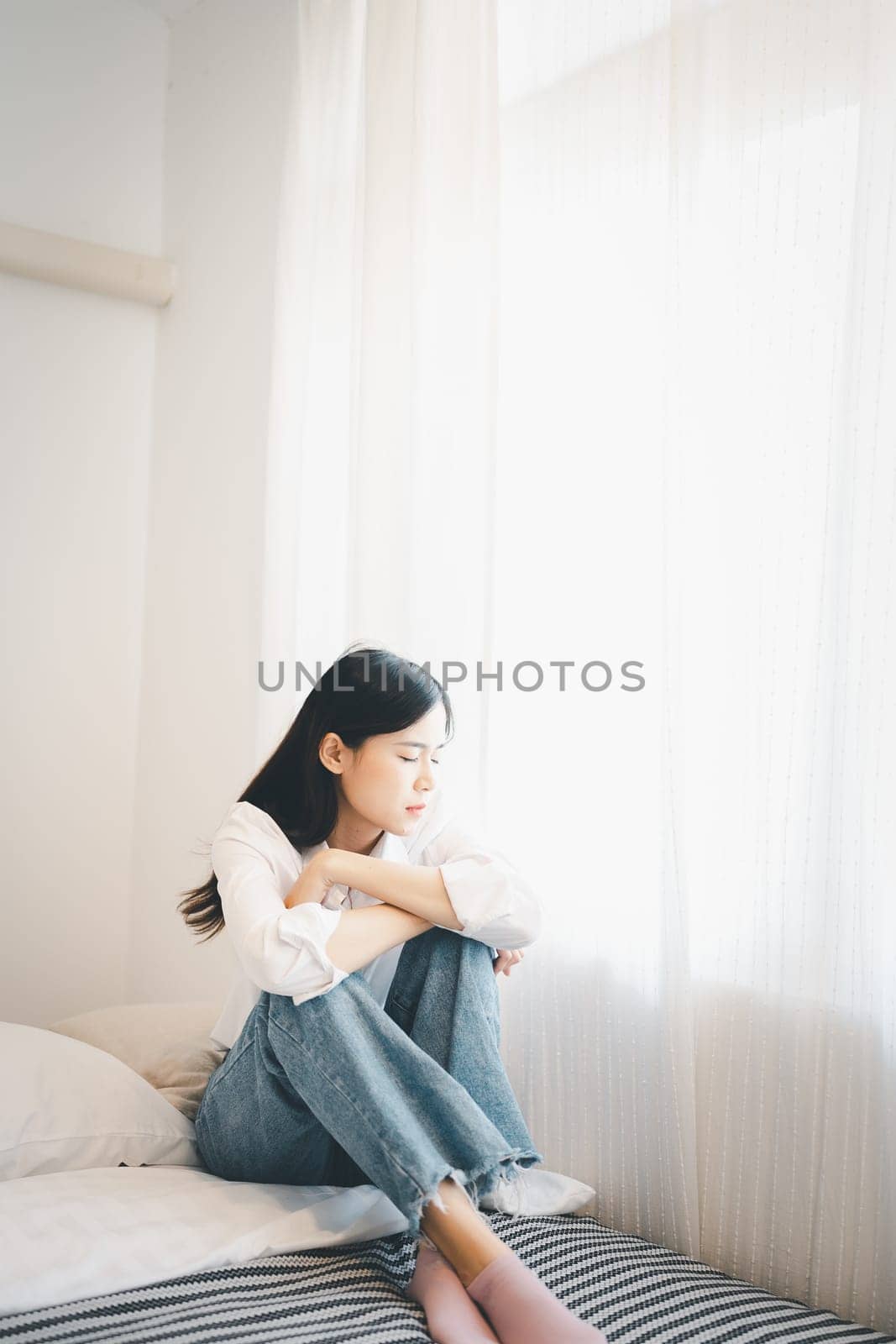 Young attractive asian woman lying at home living room couch feeling sad tired and worried suffering depression in mental health, problems and broken heart concept. by Manastrong