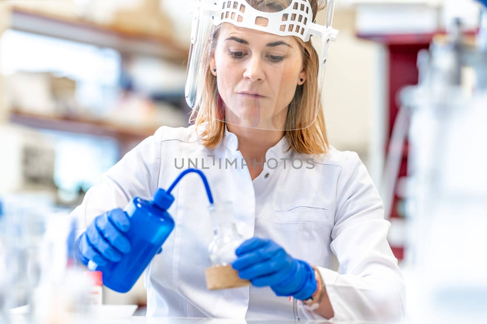 research of dangerous chemical substances in a biochemical laboratory. female scientist uses protective equipment by Edophoto