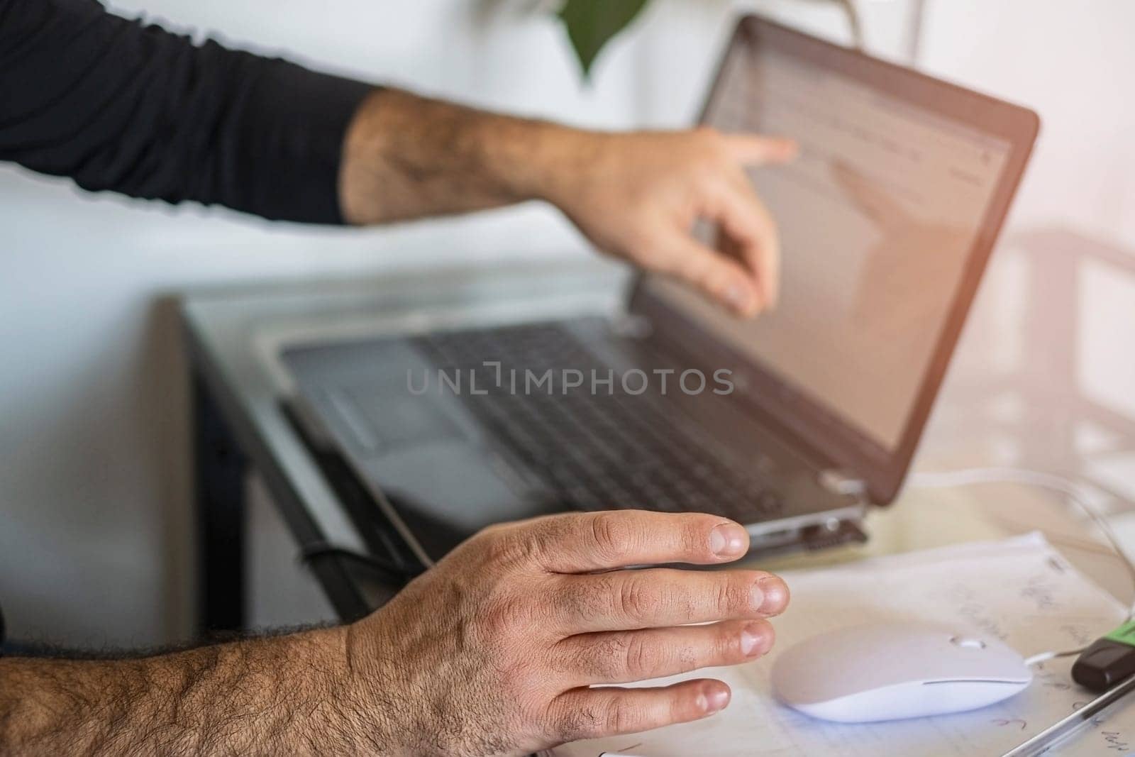 A man's using laptop hand on mouse and shows the screen by Annavish