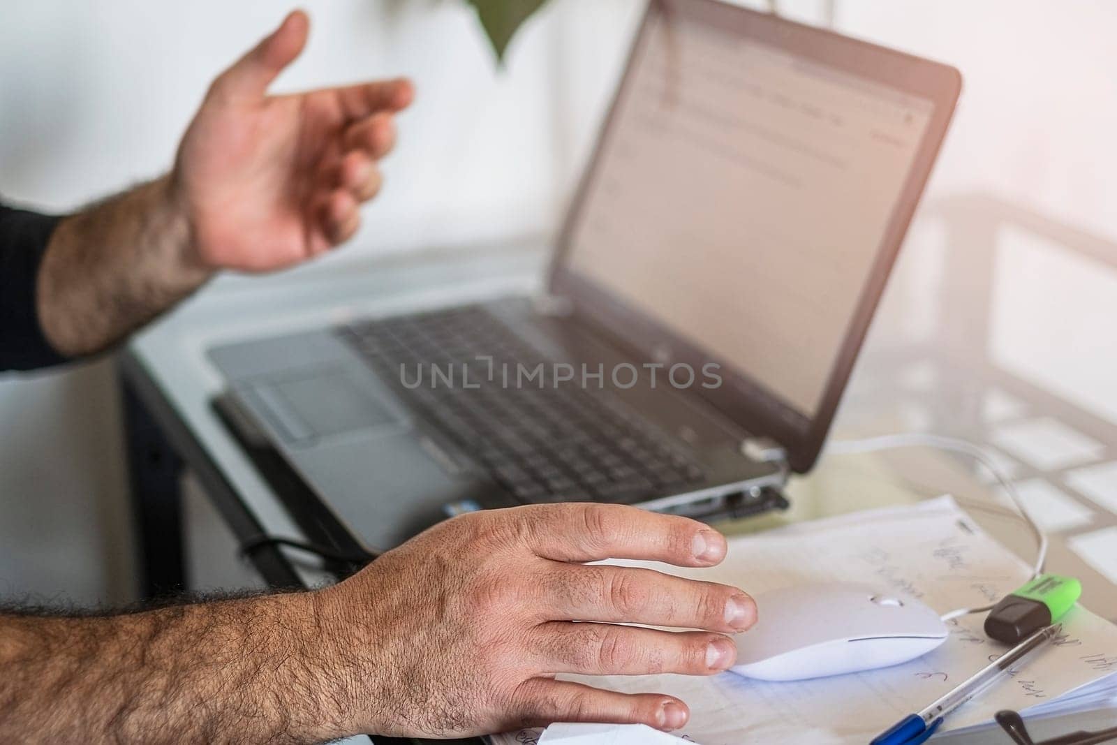 A man's using laptop hand on mouse and shows the screen.