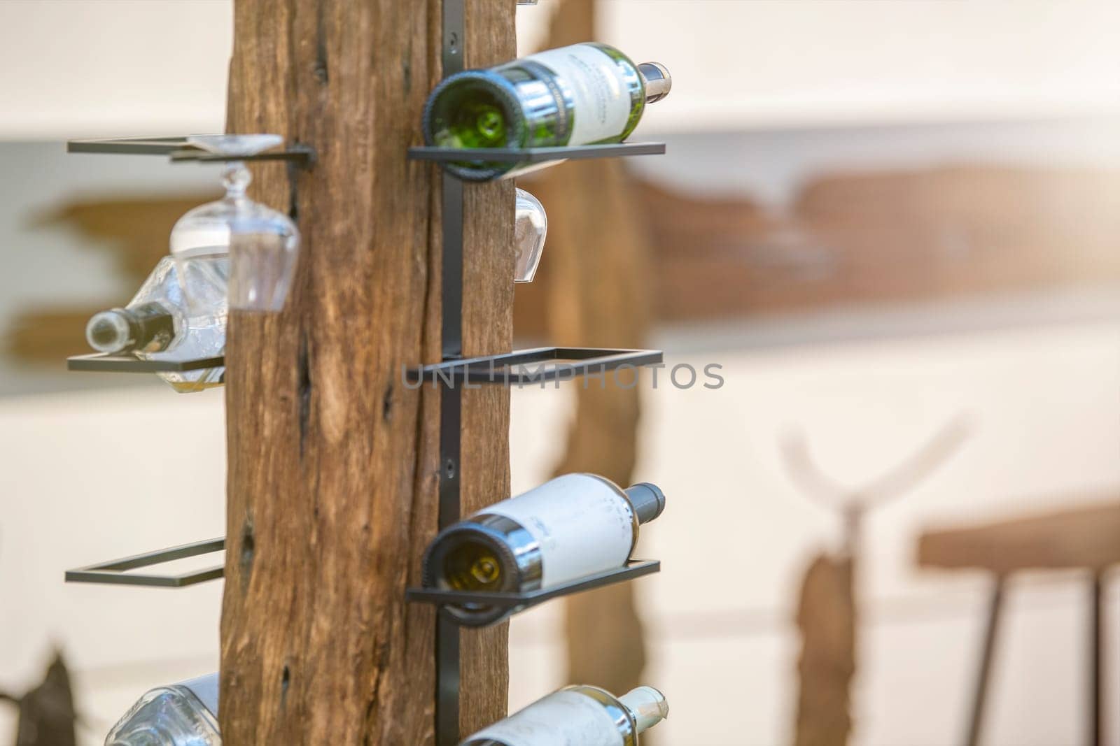 Wine storage holder made of wood and metal rustic style. Wine bottles are arranged on a holder with copy space. The concept of collecting alcoholic beverages. High quality photo