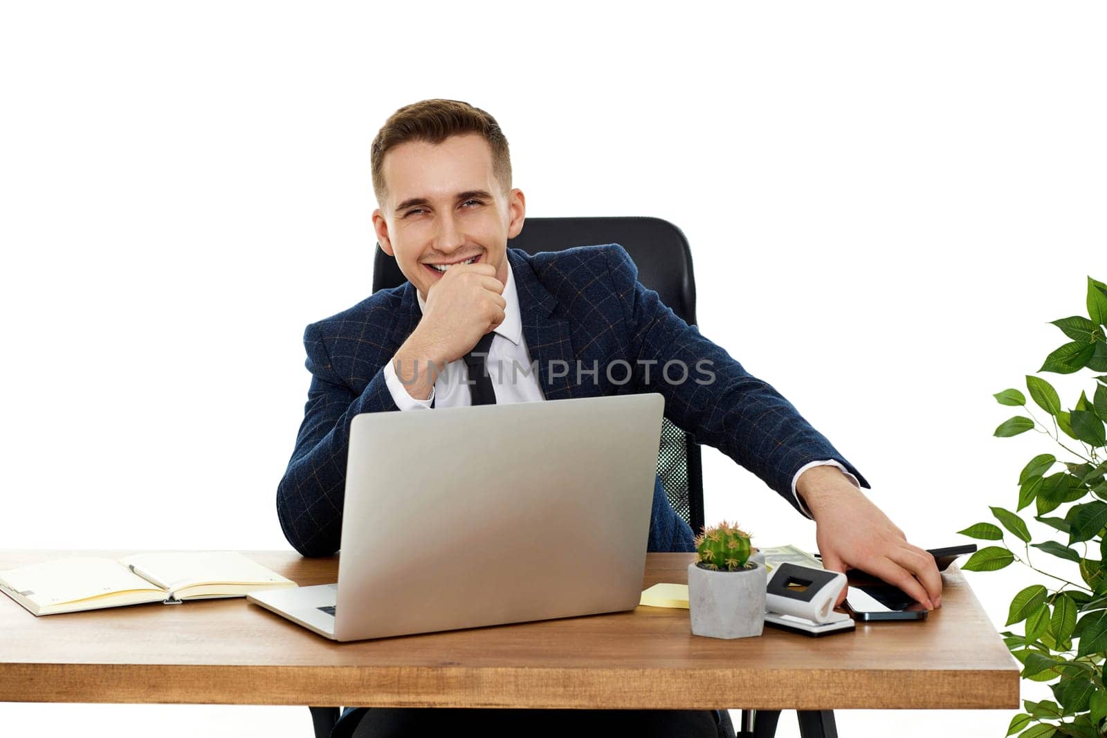 young happy businessman sitting on chair at table and resting, using laptop