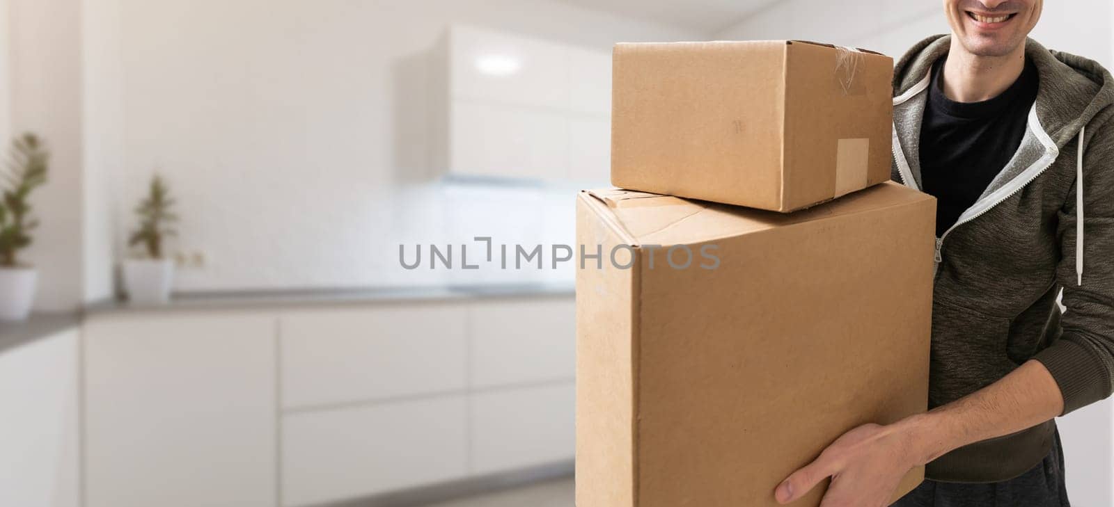 Man lifting cardboard boxes in apartment interior