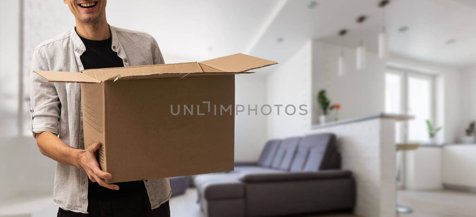 enthusiastic young man carrying cardboard box, moving out of home.