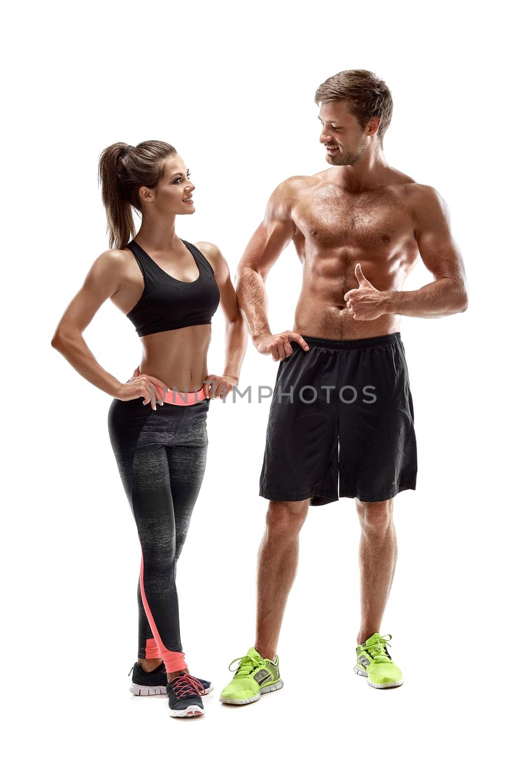 Young sportsmen couple woman and man in studio on white background. They look at each other