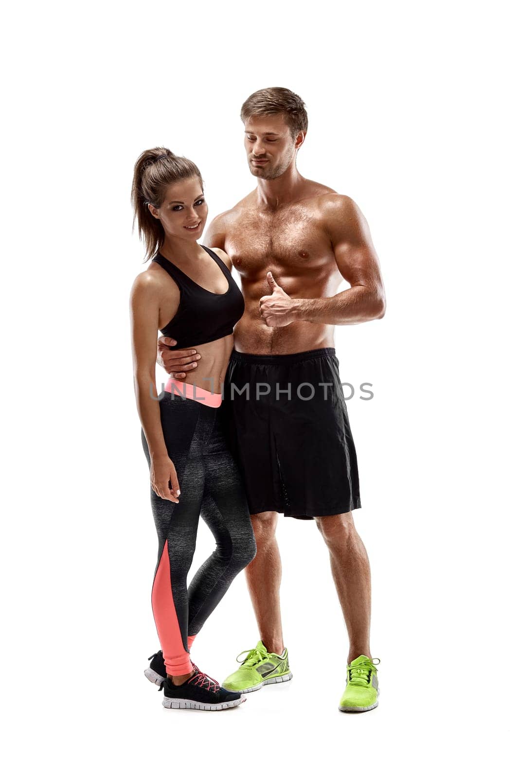 Young sportsmen couple woman and man in studio on white background. A woman looks at the camera