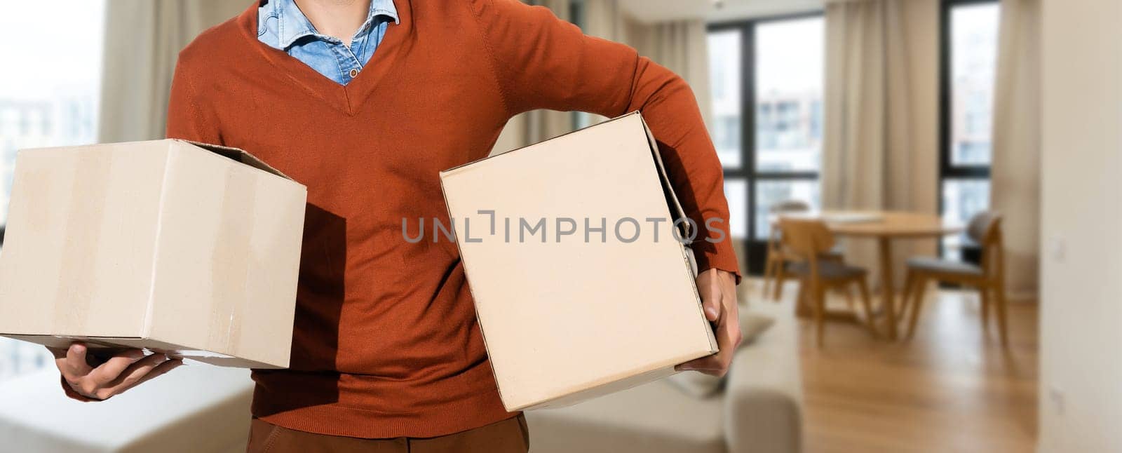 Young smiling logistic delivery man holding the box.