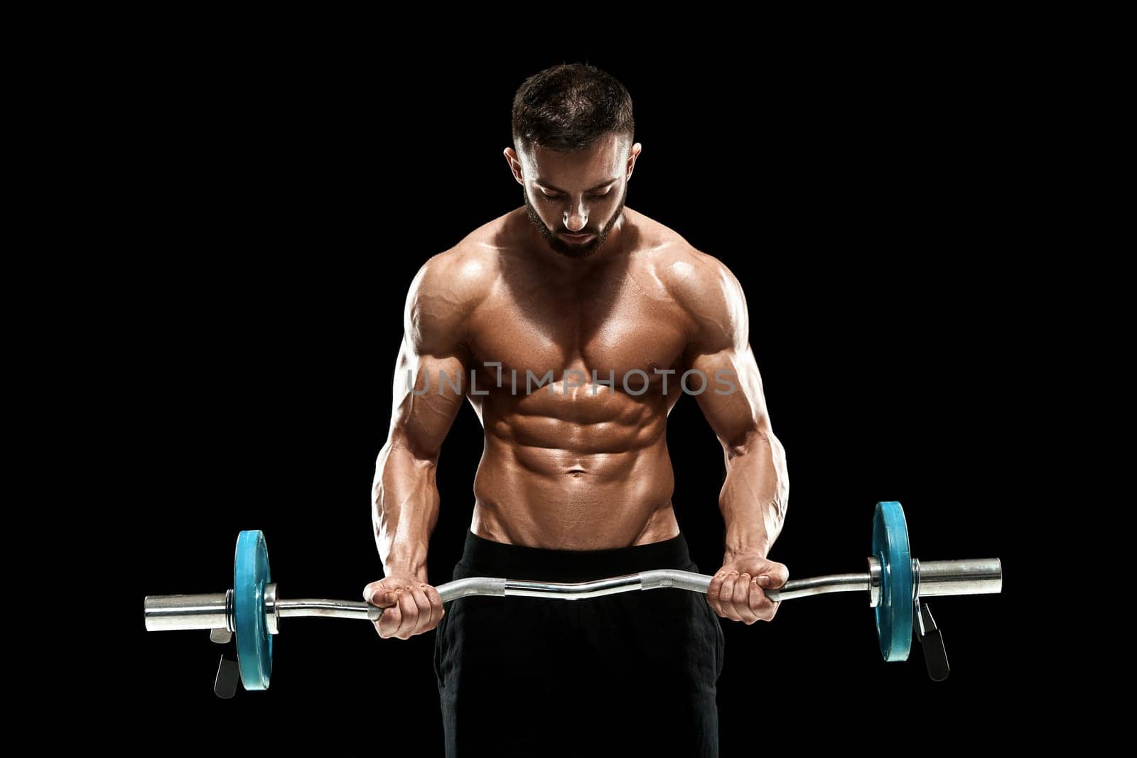 Close up of young muscular man lifting weights over dark background