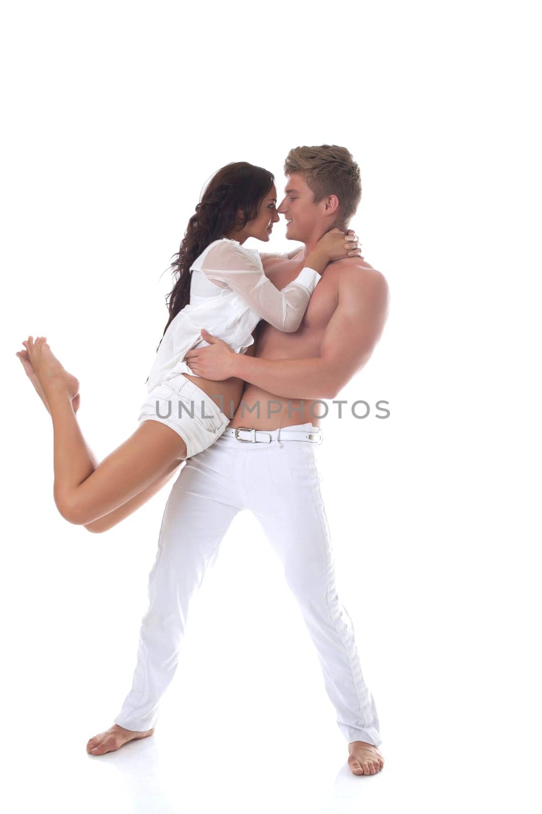 Beautiful smiling couple dancing in studio, isolated on white