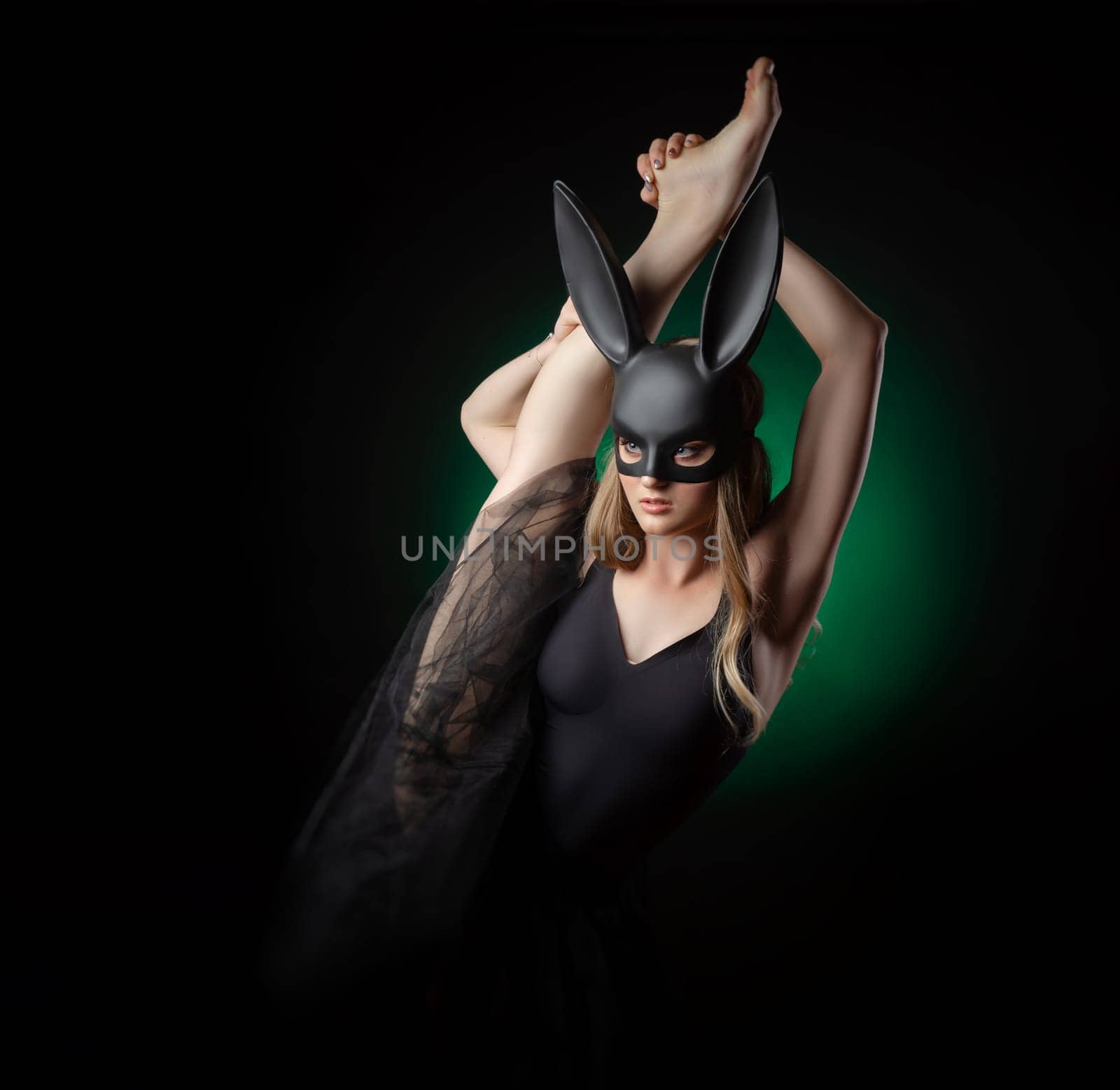 ballerina girl with a raised leg in a rabbit mask on a dark background by Rotozey