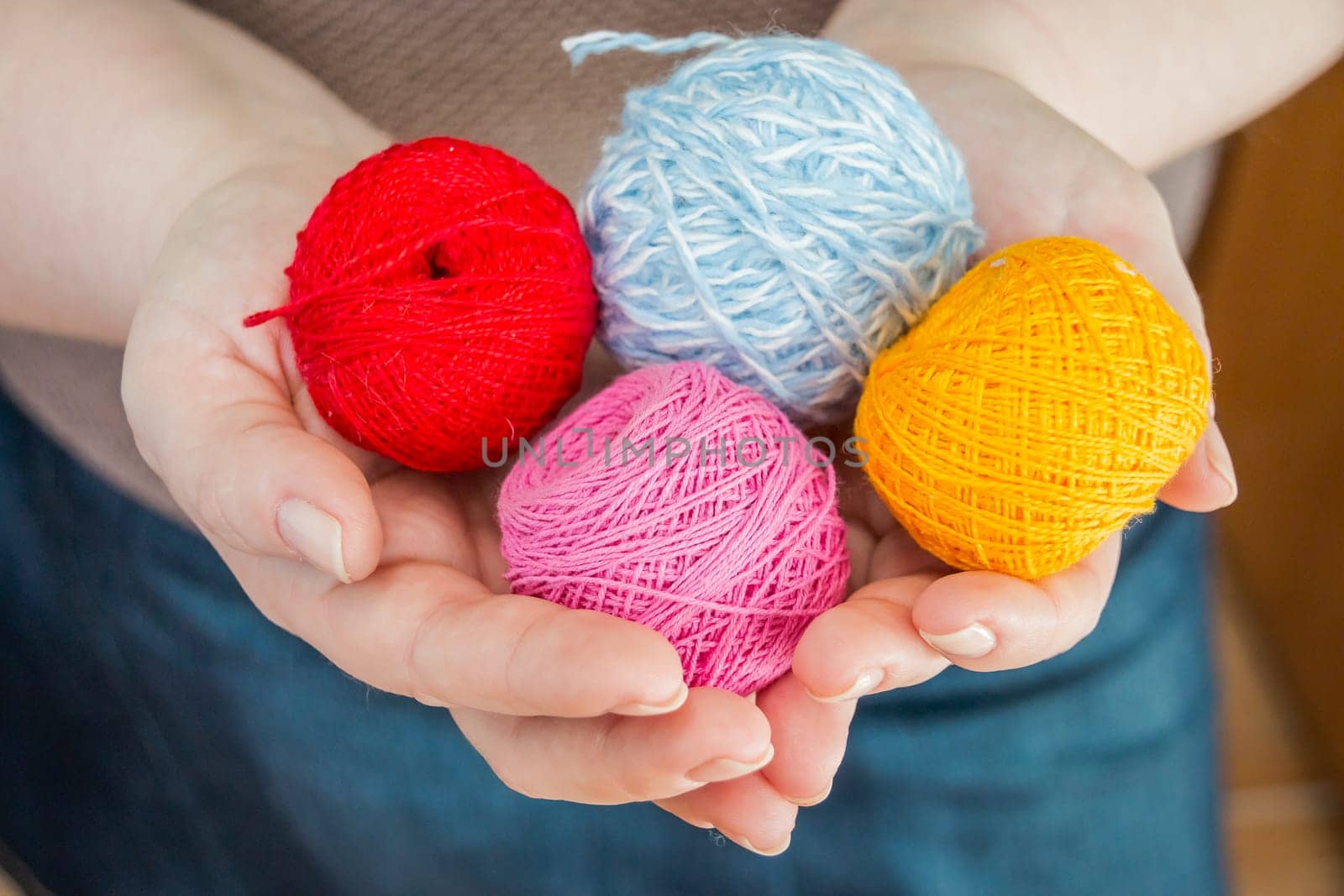 female hands holding stitching, yarn, ingrain, thread in the form of heart close up. materials for handmade and handiwork - sewing, embroidery, knitting.