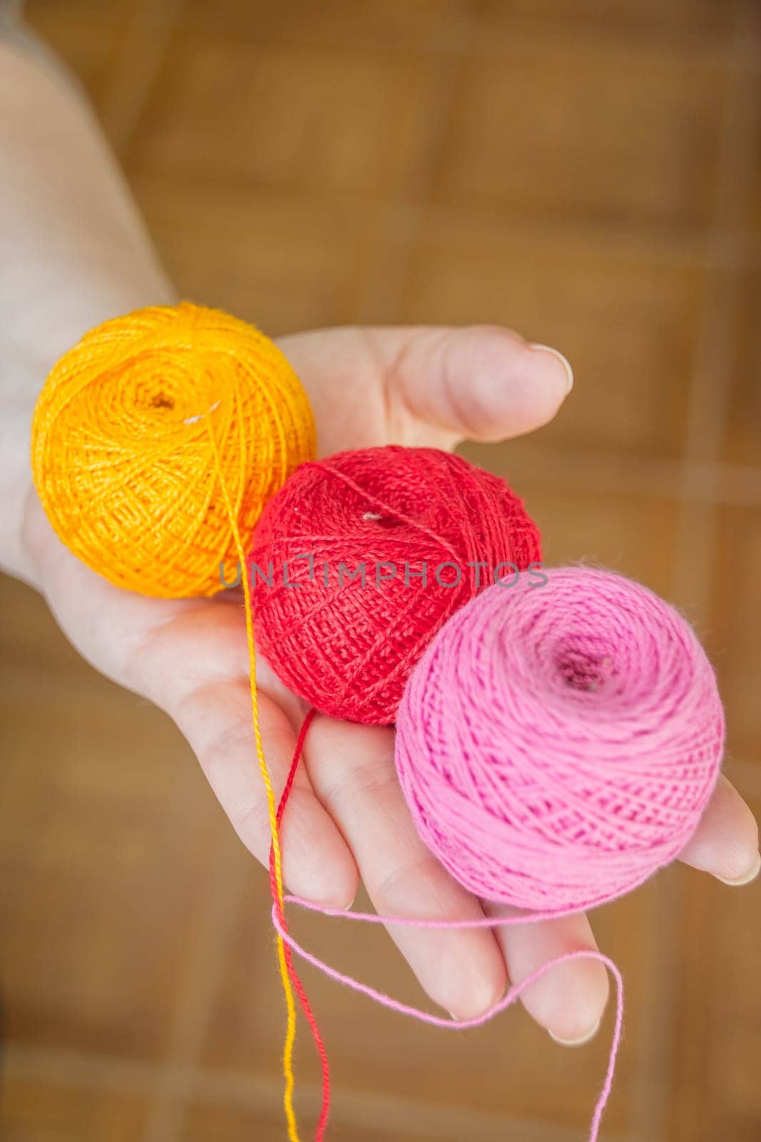 female hands holding stitching, yarn, ingrain, thread in the form of heart close up. materials for handmade and handiwork - sewing, embroidery, knitting.