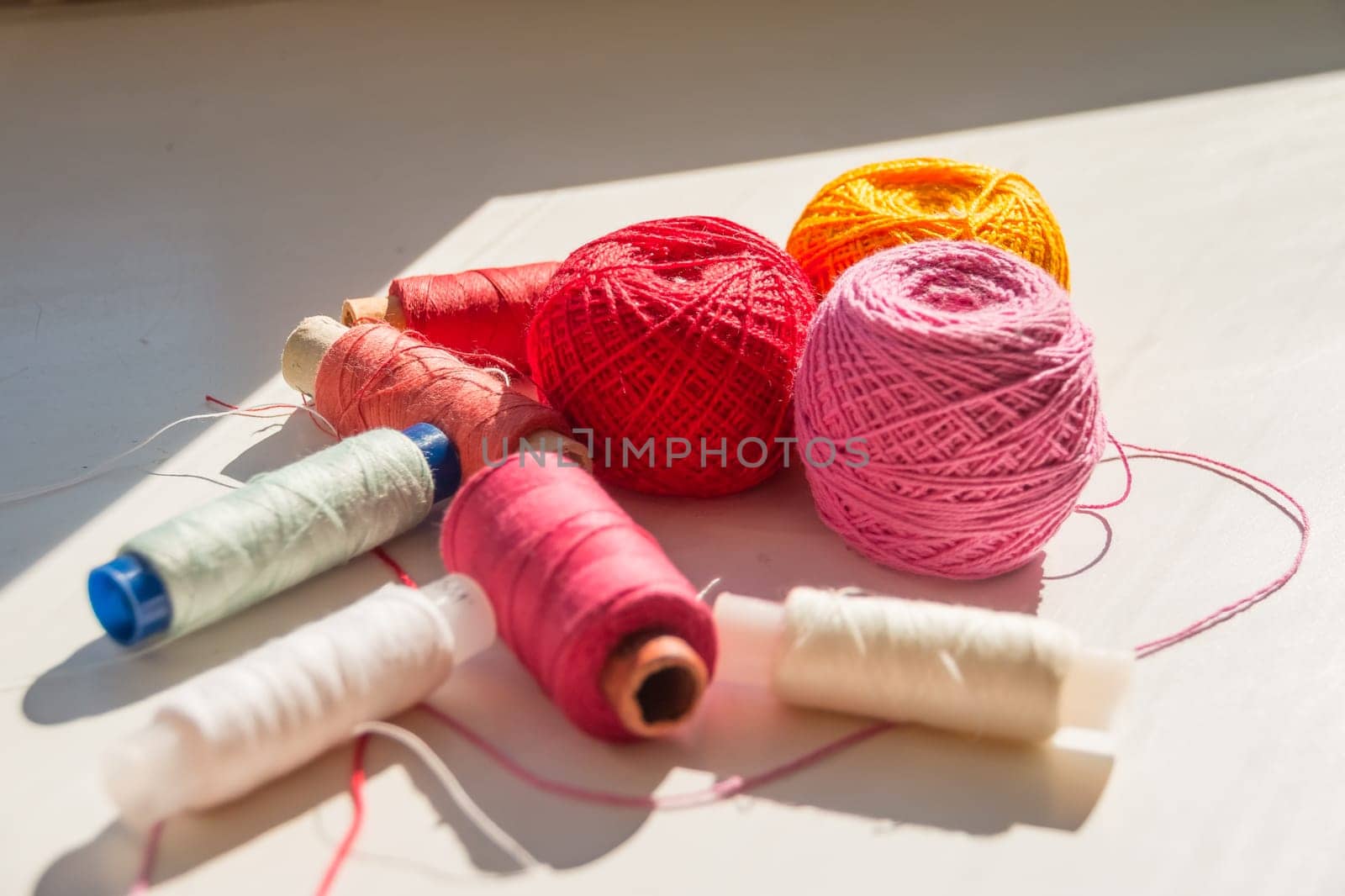 Flat lay composition with sewing threads on color background