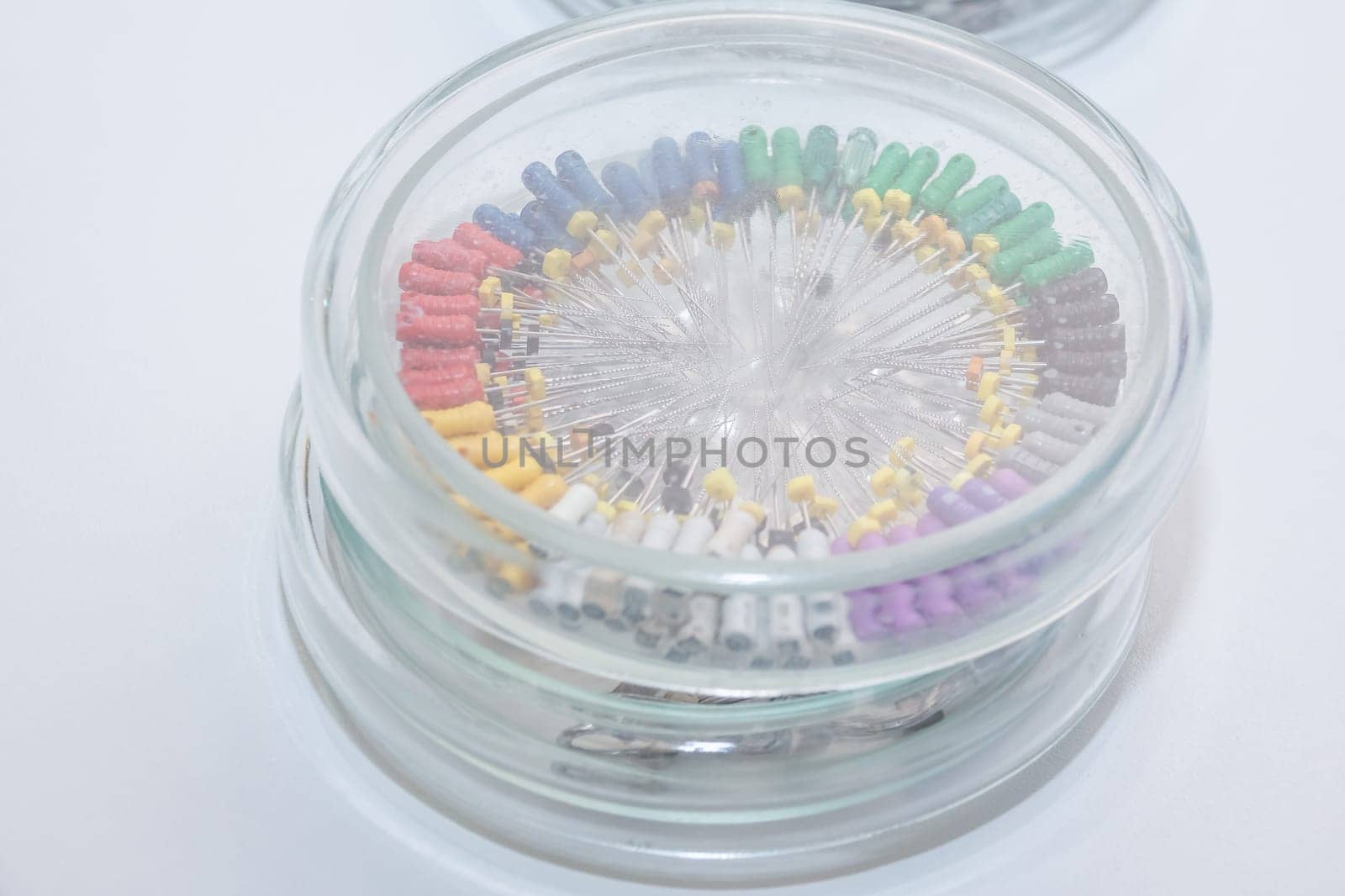 Dental tools in the glass round box. Dental instruments - k-files. Close-up dentist tools capture. Dentist clinic.