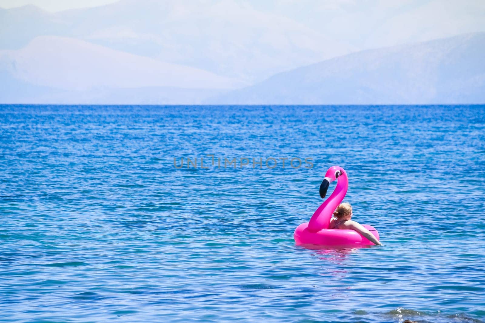 Girl having Fun with Flamingo rubber ring. Swimming and relaxing