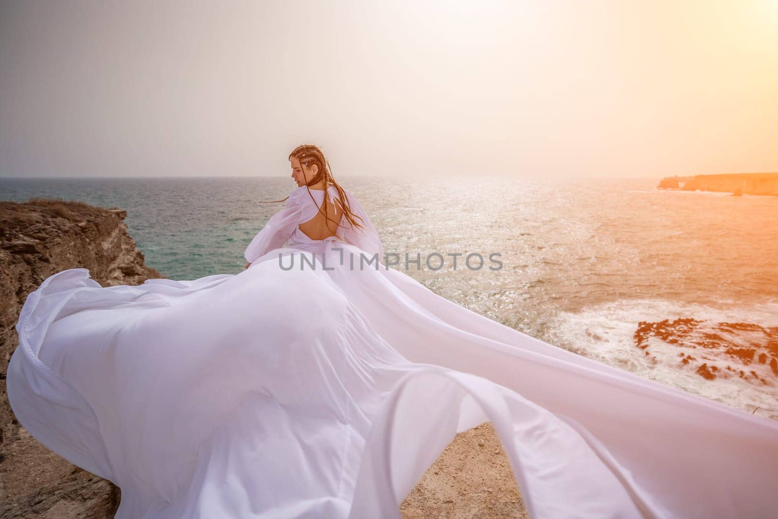 Woman sea white dress. Happy freedom woman on the beach enjoying and posing in white dress. Rear view of a girl in a fluttering white dress in the wind. Holidays, holidays at sea. by Matiunina