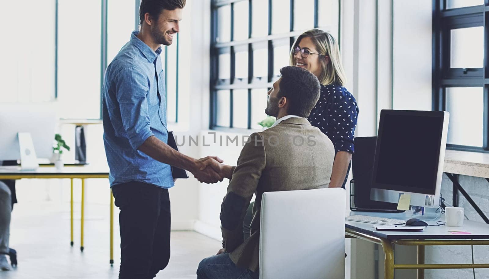 Handshake, meeting and leadership with businesspeople in office for b2b, collaboration or teamwork. Support, happy and deal with employee shaking hands in digital agency for creative, vision or goals by YuriArcurs