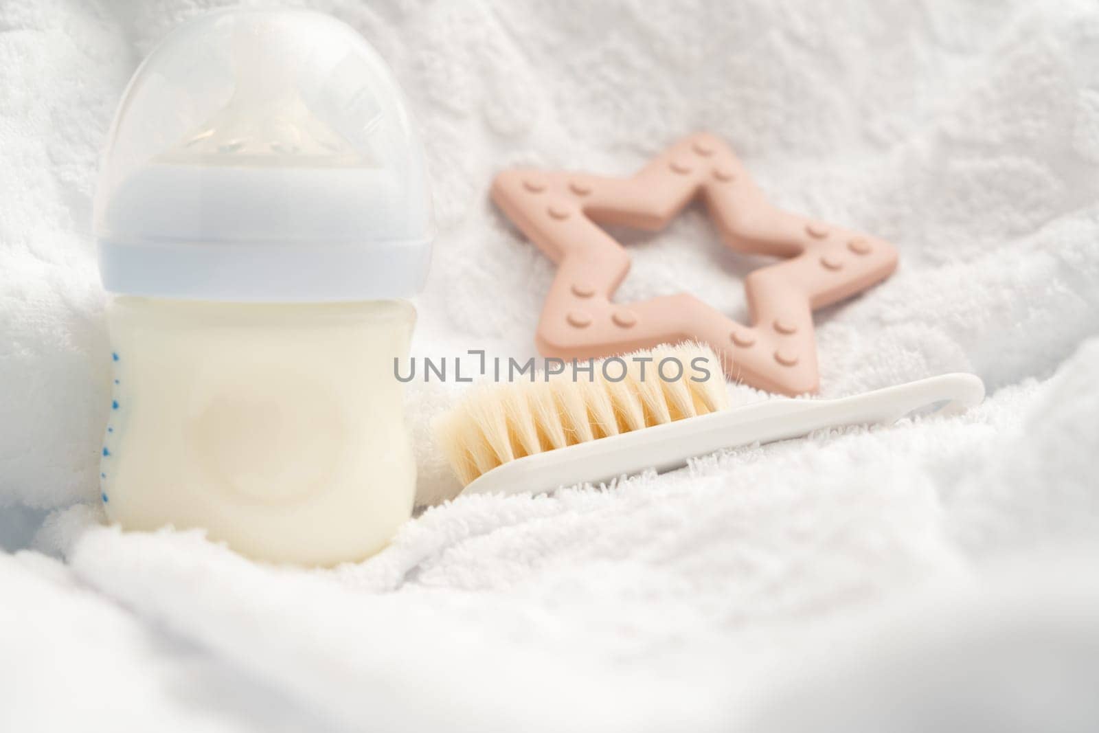 Several attributes of a newborn milk bottle toy and soft brush.