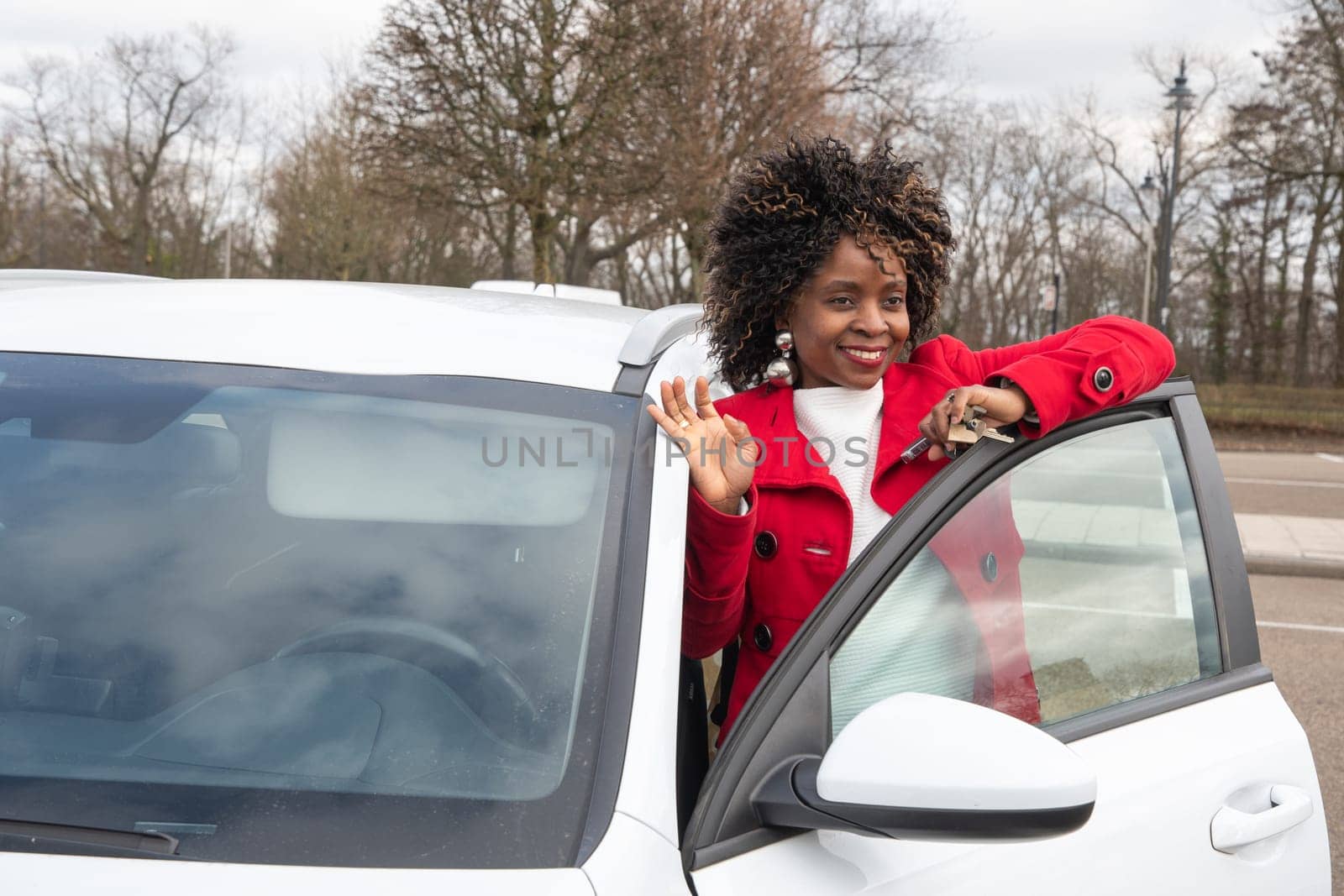 Confident african american businesswoman in trendy clothes standing near new white car, High quality photo