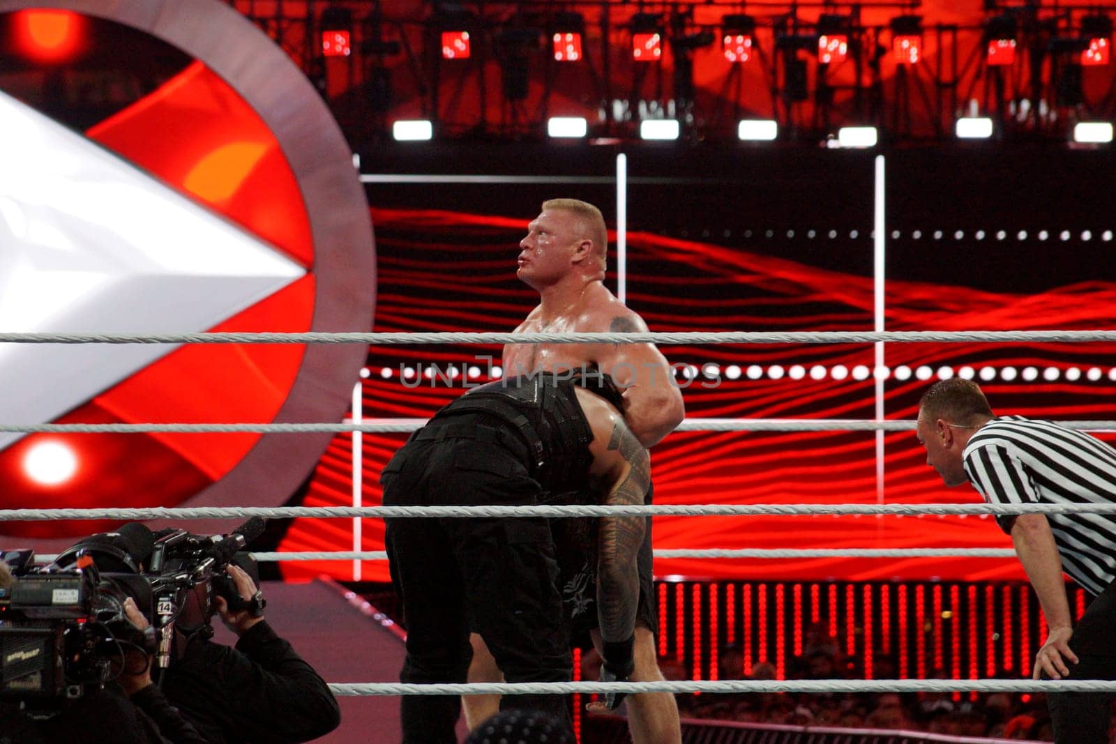 Santa Clara, California - March 29, 2015: WWE Champion Brock Lesner has Roman Reigns in a front headlock at the showcase of the immortals, Wrestlemania 31. The crowd is on their feet as night falls and the lights illuminate the Levi's Stadium.