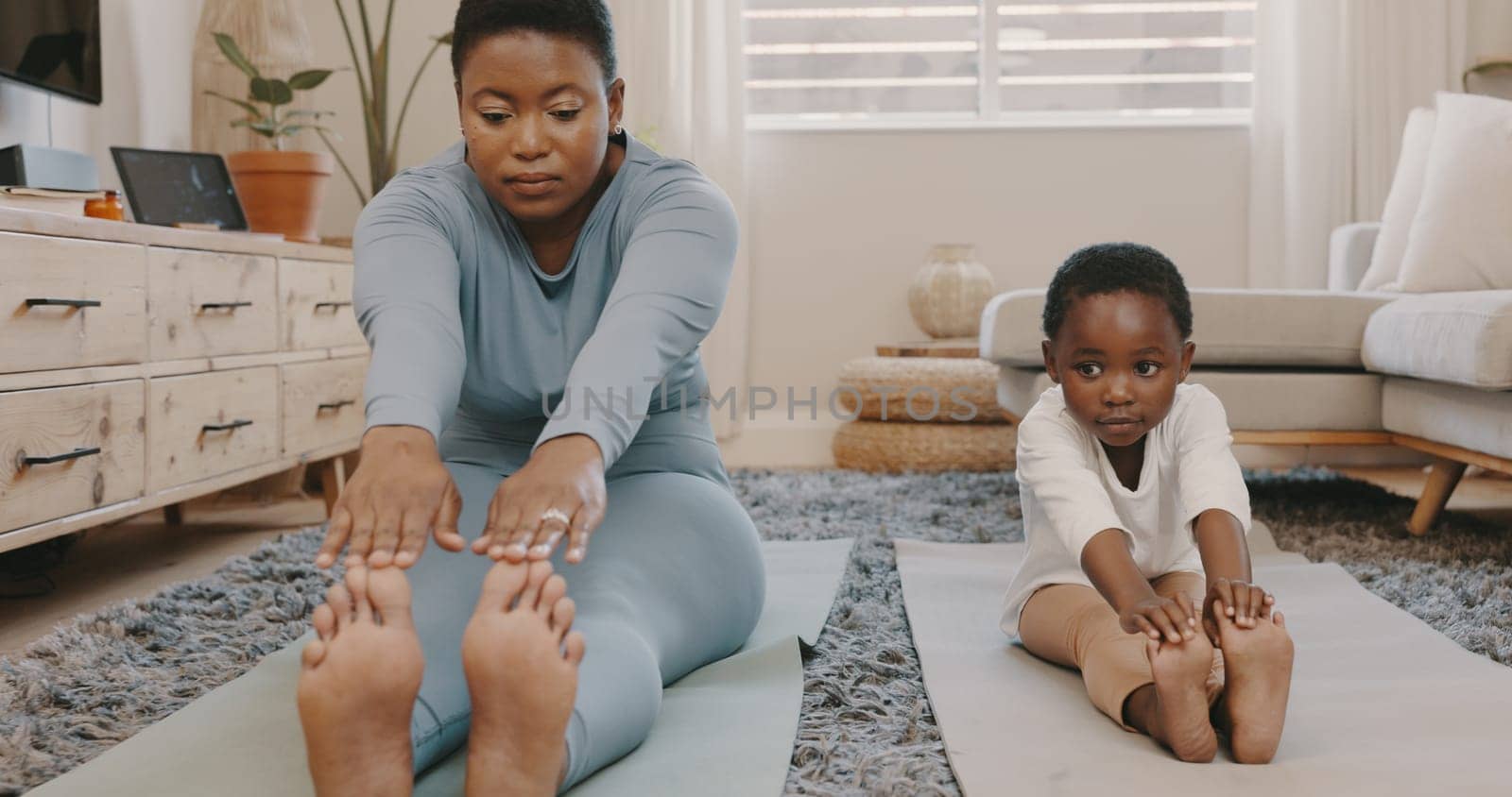 Shot of a young mother and daughter doing yoga at home by YuriArcurs