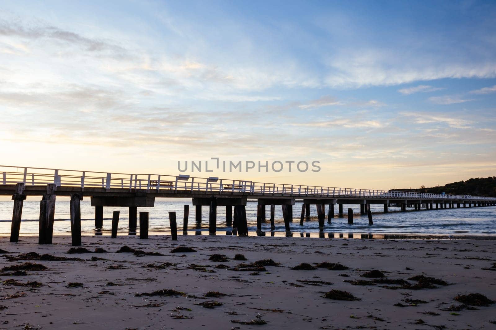 A view of the famous causeway leading to Granite Island Recreation Park at sunrise in Victor Harbor on a sunny autumn day in South Australia, Australia
